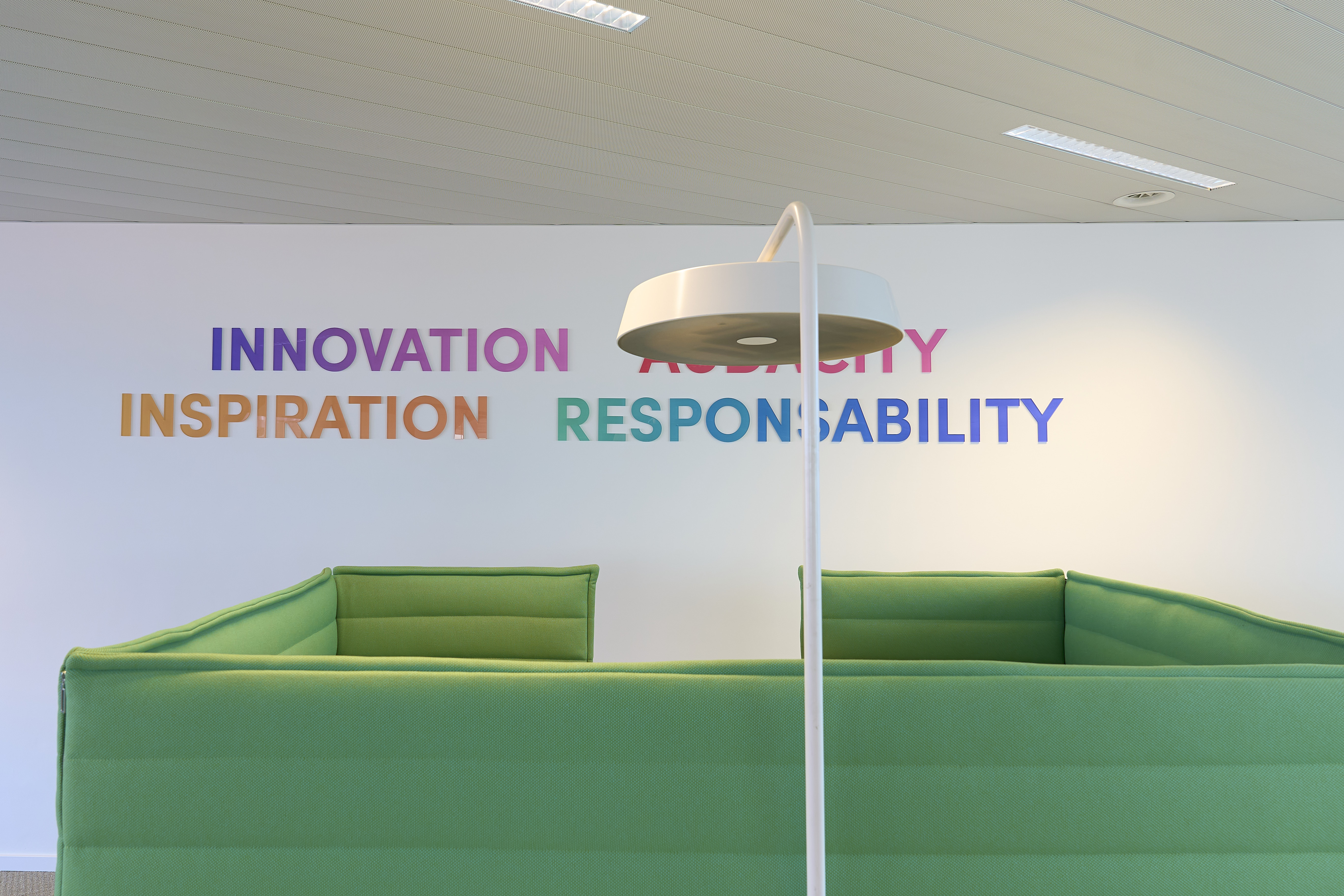 un canapé vert dans une pièce avec une lampe