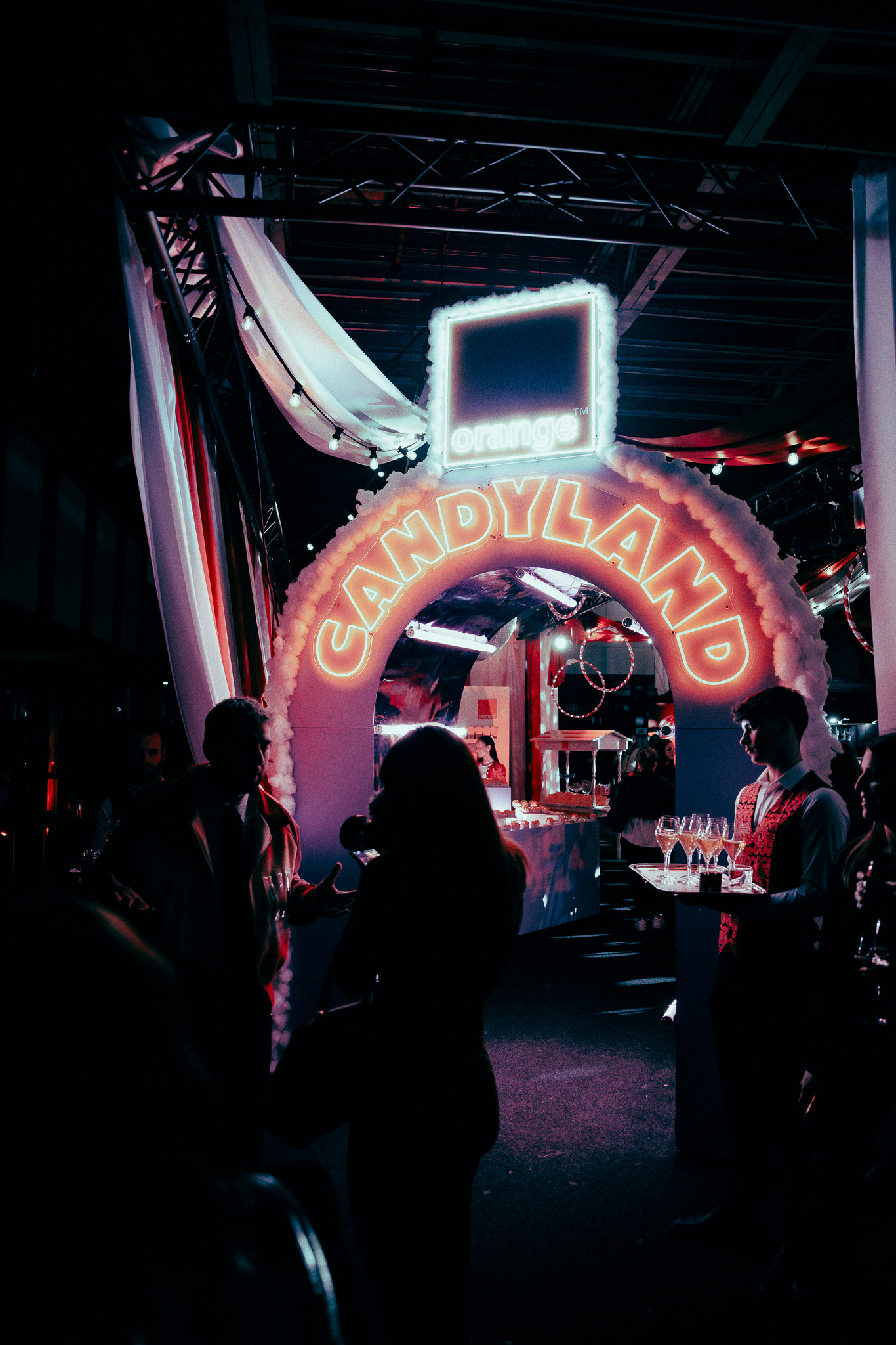 un groupe de personnes debout devant une enseigne au néon
