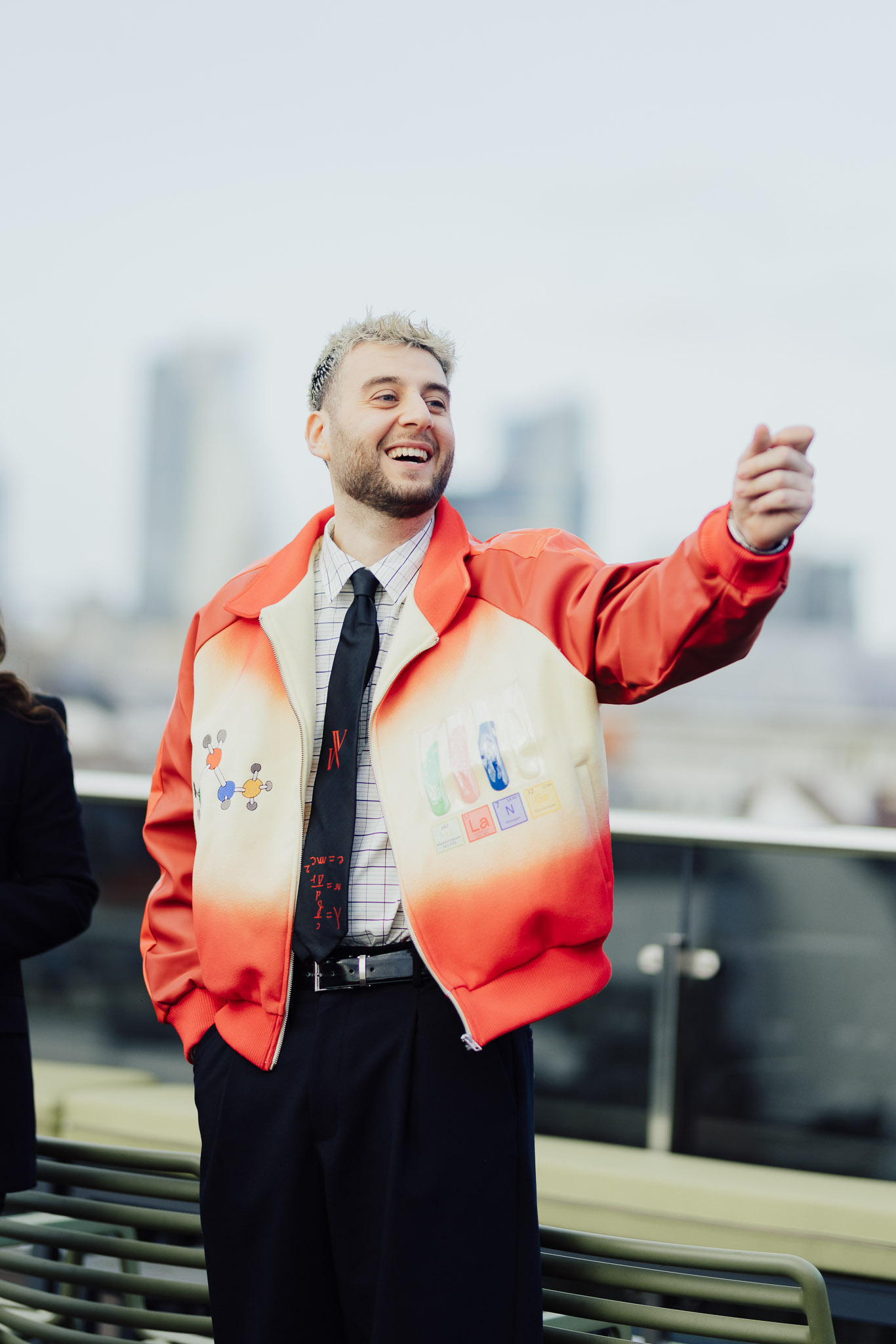 un homme en veste rouge qui montre du doigt